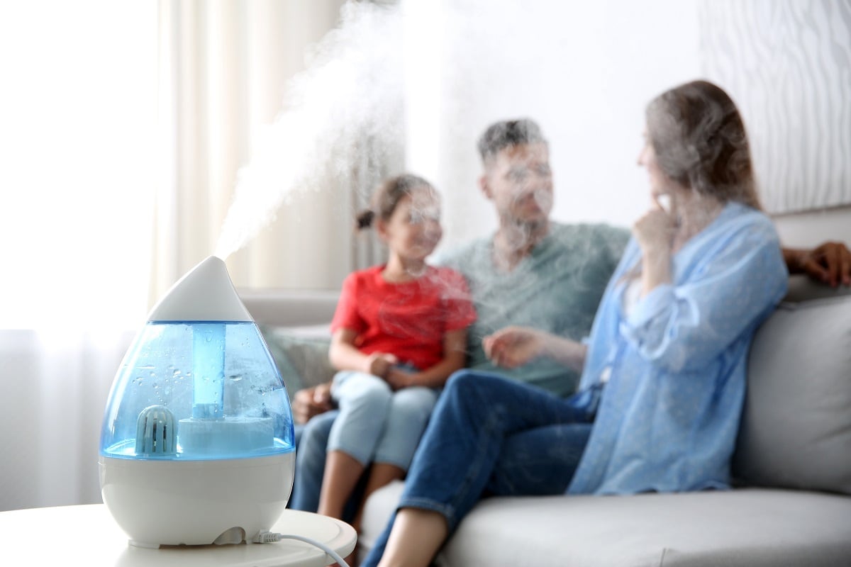 Improve Indoor Climate - Modern air humidifier and blurred family on background