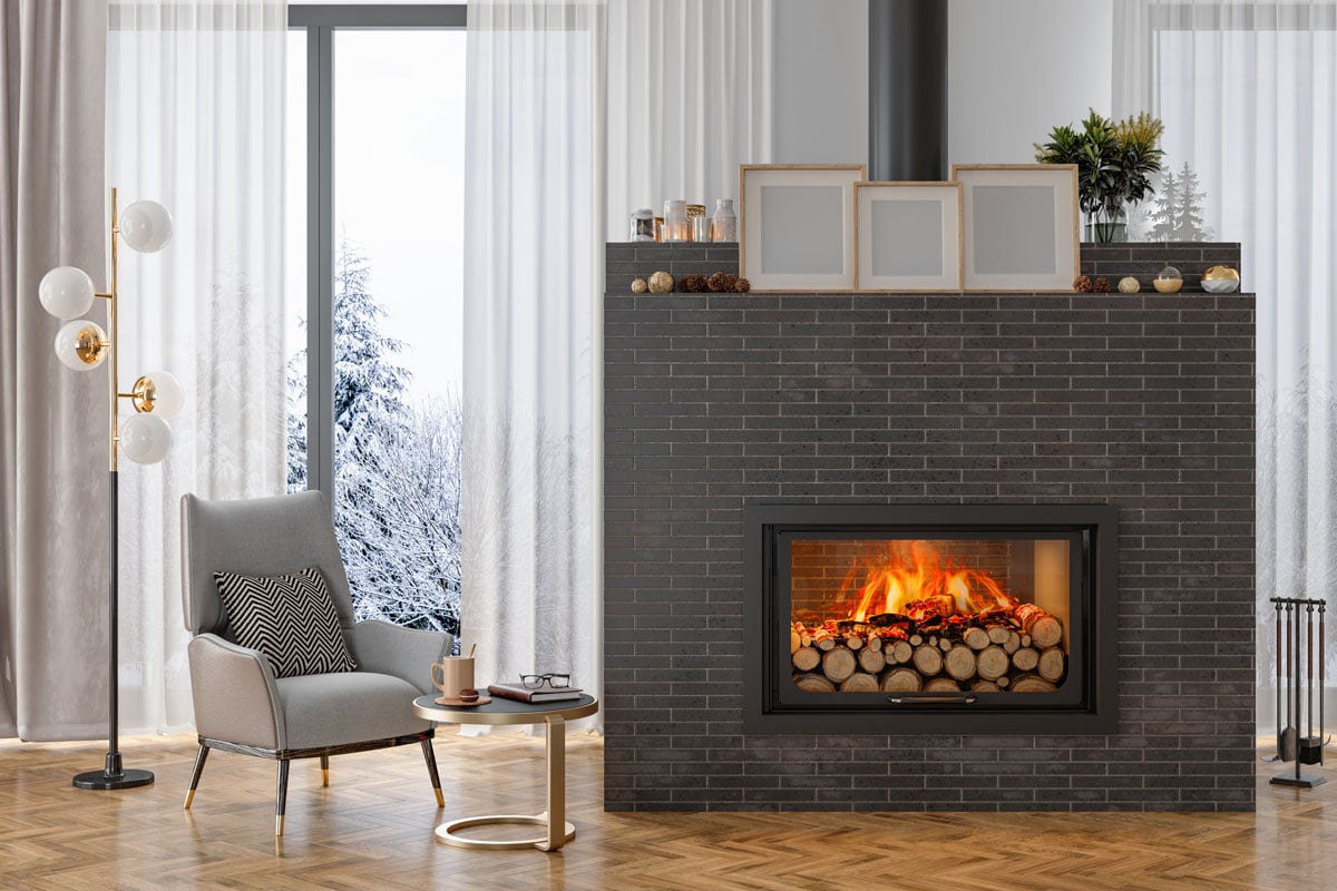 Luxury Living Room Interior With Armchair, Burning Fireplace And Snow View From The Window
