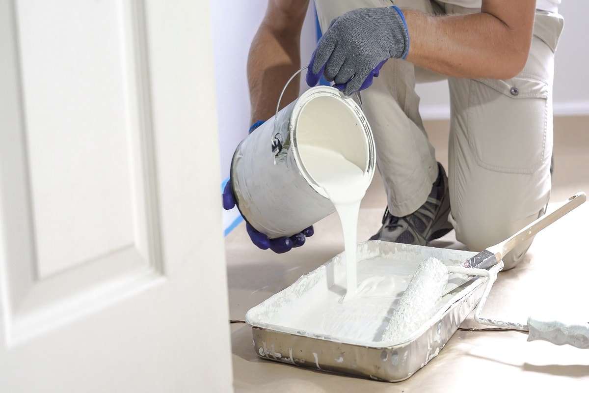 Mix The Drylok Paint - Professional interior construction worker pouring white color paint to tray.