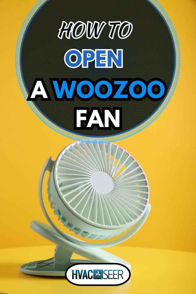 Modern electric fan on table against yellow background