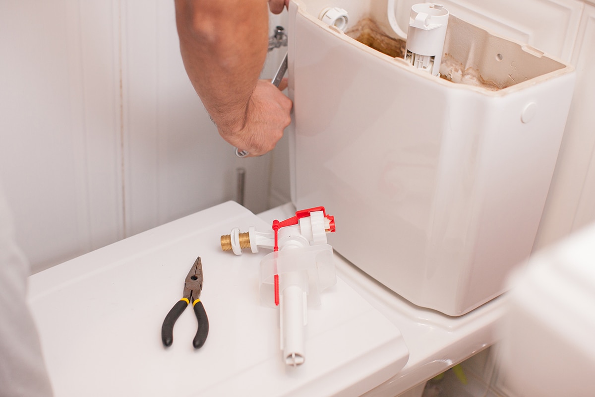 Plumber repairing toilet valve