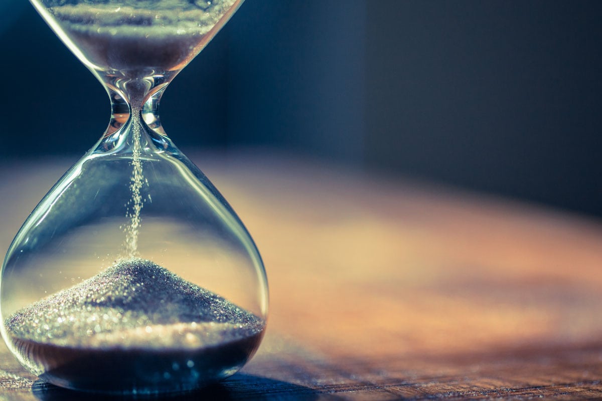 Sand running through the bulbs of an hourglass measuring the passing time in a countdown to a deadline