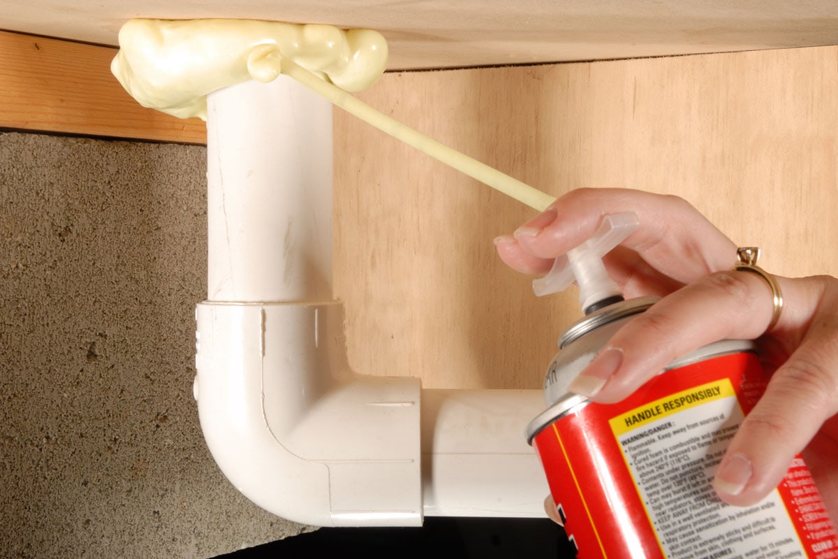Sealing the air leaks around plumbing penetrations underneath a home with an insulating expandable foam sealant