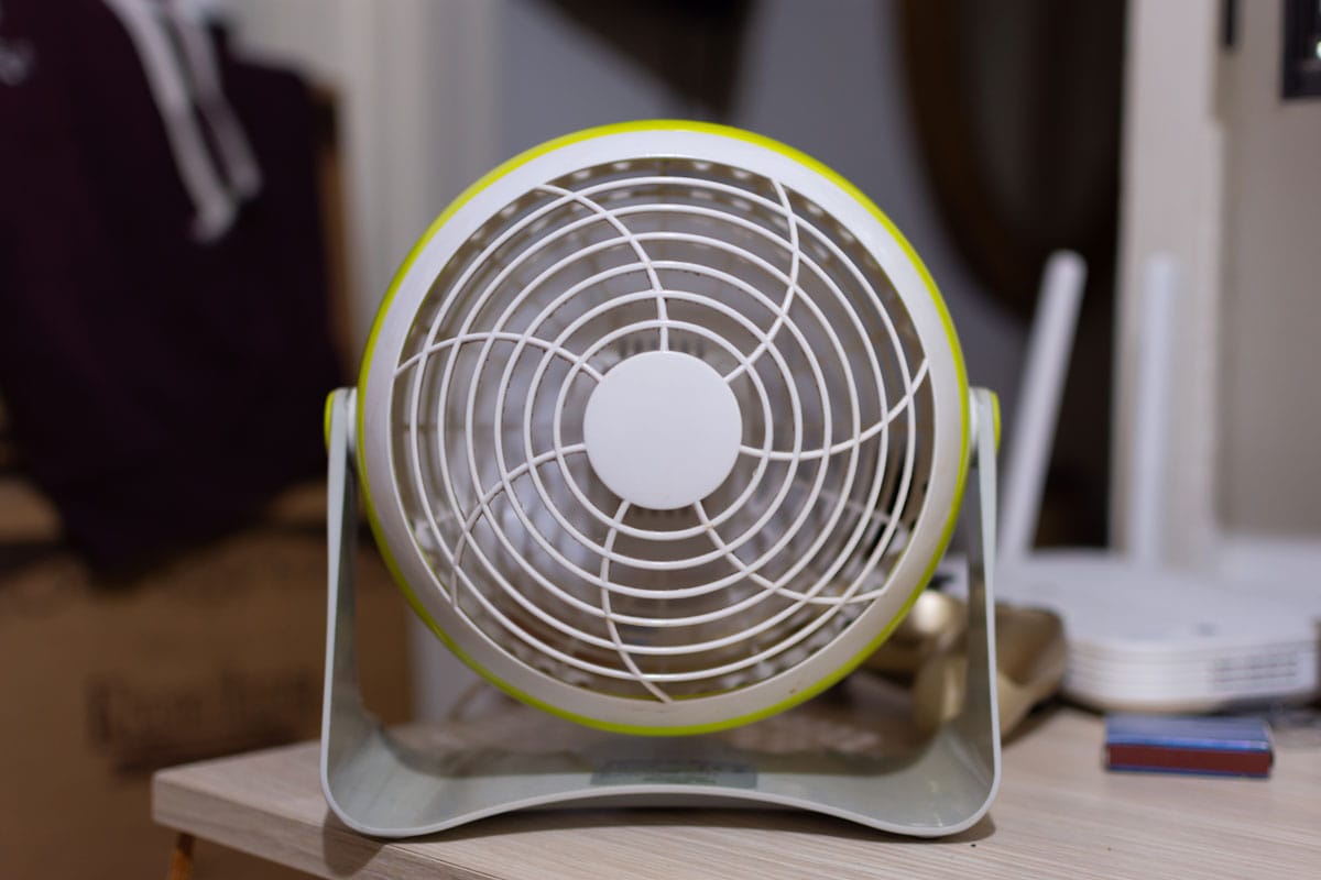 Small electric desk fan on top of the working desk
