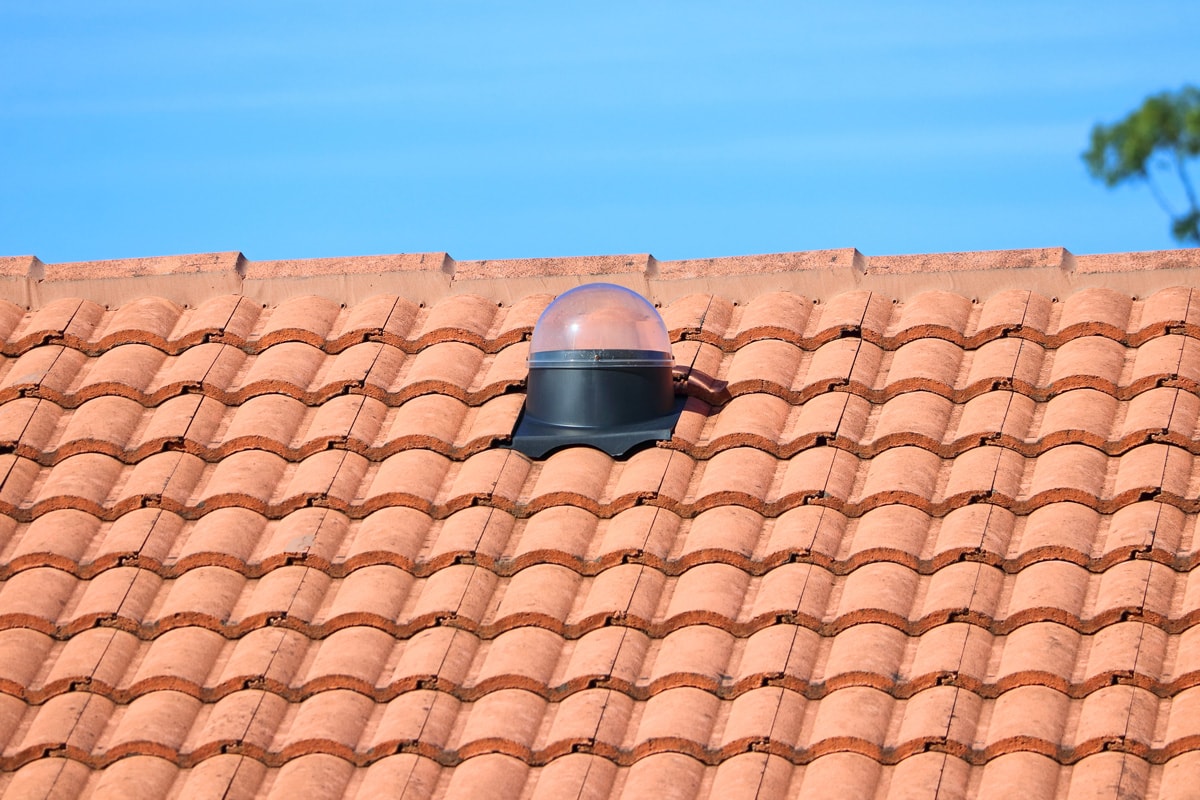 Solar light tube on a tiled roof.