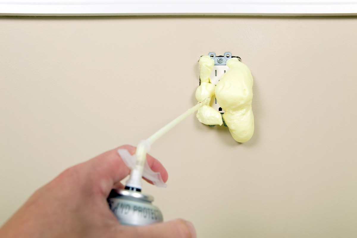 Spraying expanding foam in between the gaps of the outlet