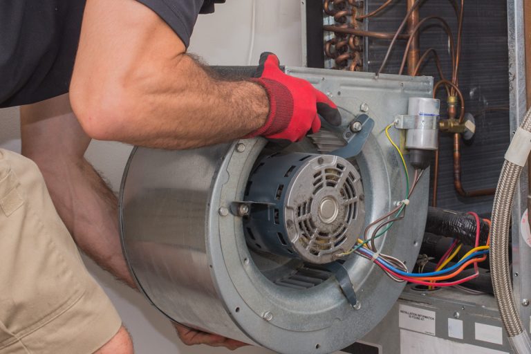 Technician removing a blower motor from air handler, How To Change Blower Speed On Carrier Furnace