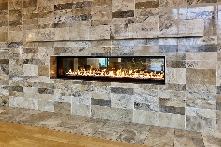 View of beautiful lit gas fireplace surrounded by modern tile, How To Use The Remote For My Gas Fireplace?