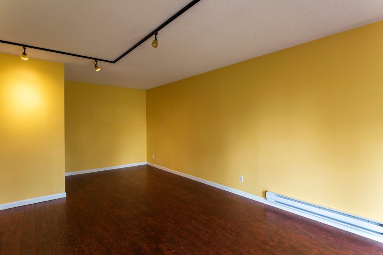 View of empty living room in a modern new apartment condo house interior with empty yellow walls., Baseboard Heater Stays On When Thermostat Is Off - Why And What To Do?