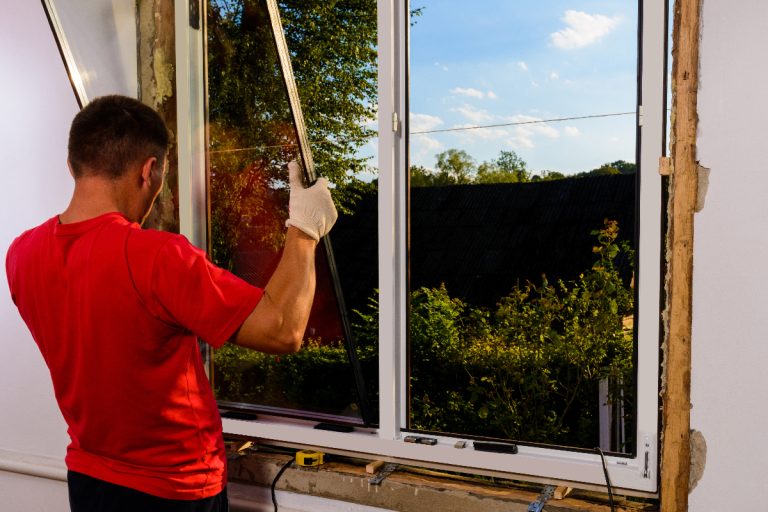 A worker inserts glass into the window frame, Telltale Signs Of Poorly Installed Windows For Homeowners [Inc. Tips To Repair]!