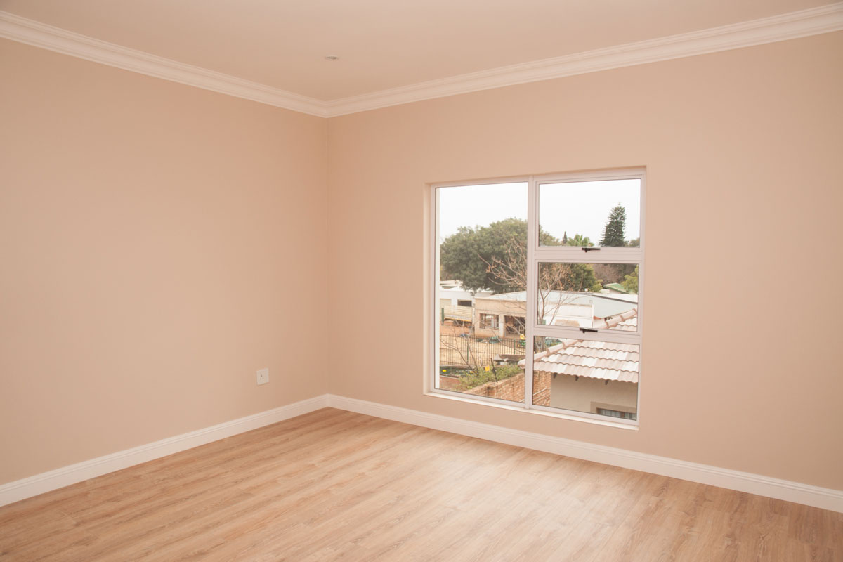 empty bedroom, looking towards the window over the laminated floor, of a new house