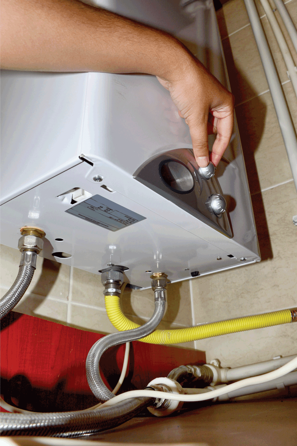 man manually adjusting water heater at home