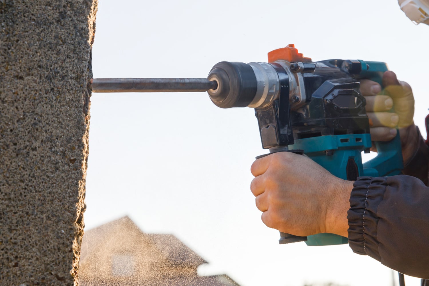 A male installer works with a hammer drill. Construction works.