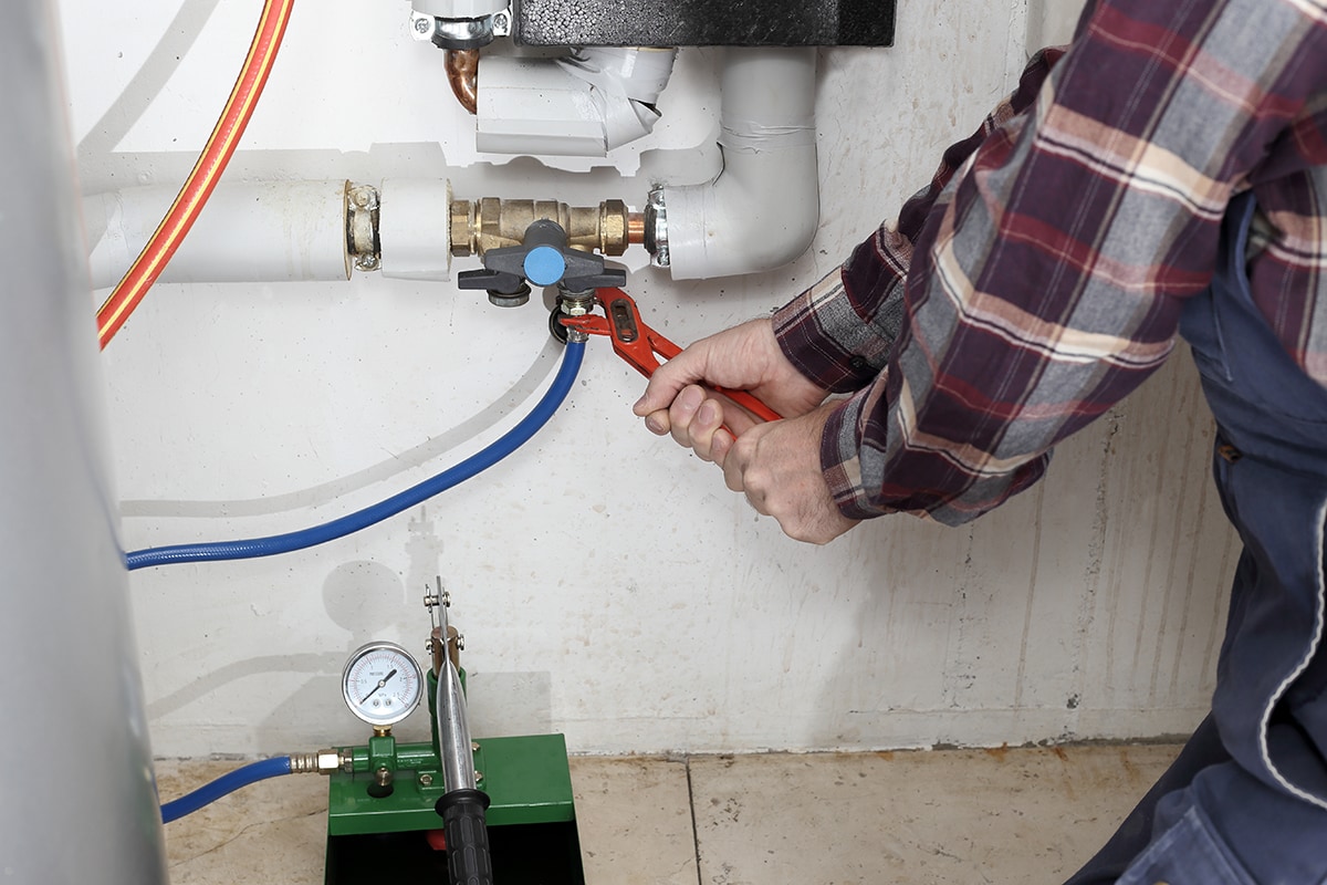 A plumber powers flushes a heating system