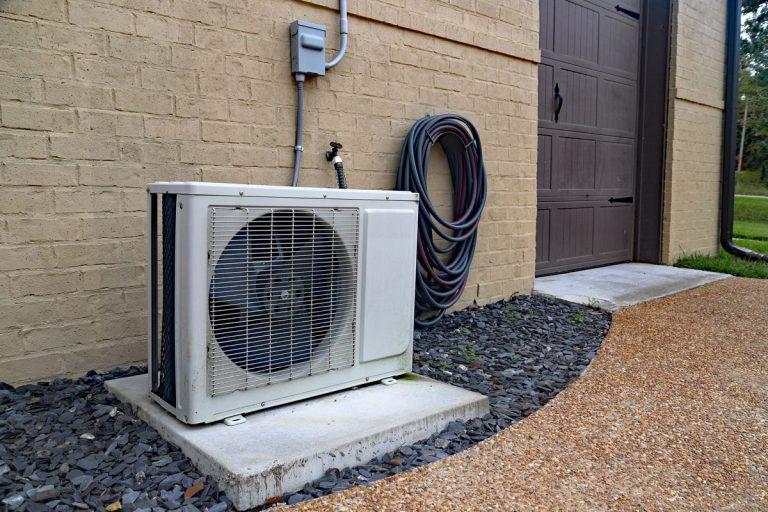 Air Conditioner mini split system next to home with painted brick wall, How To Check & Recharge Mini Split Freon [Step By Step Guide]