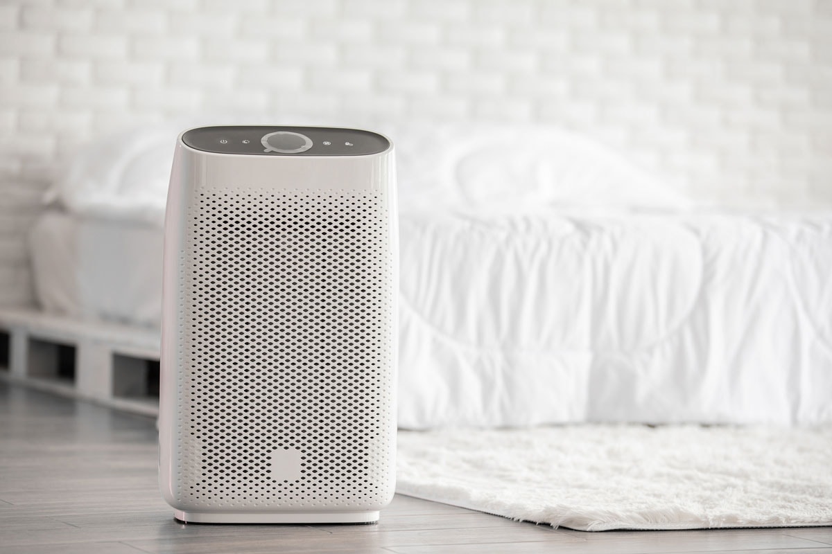 Air purifier in cozy white bed room for filter and cleaning removing dust PM2.5 HEPA in home,for fresh air and healthy