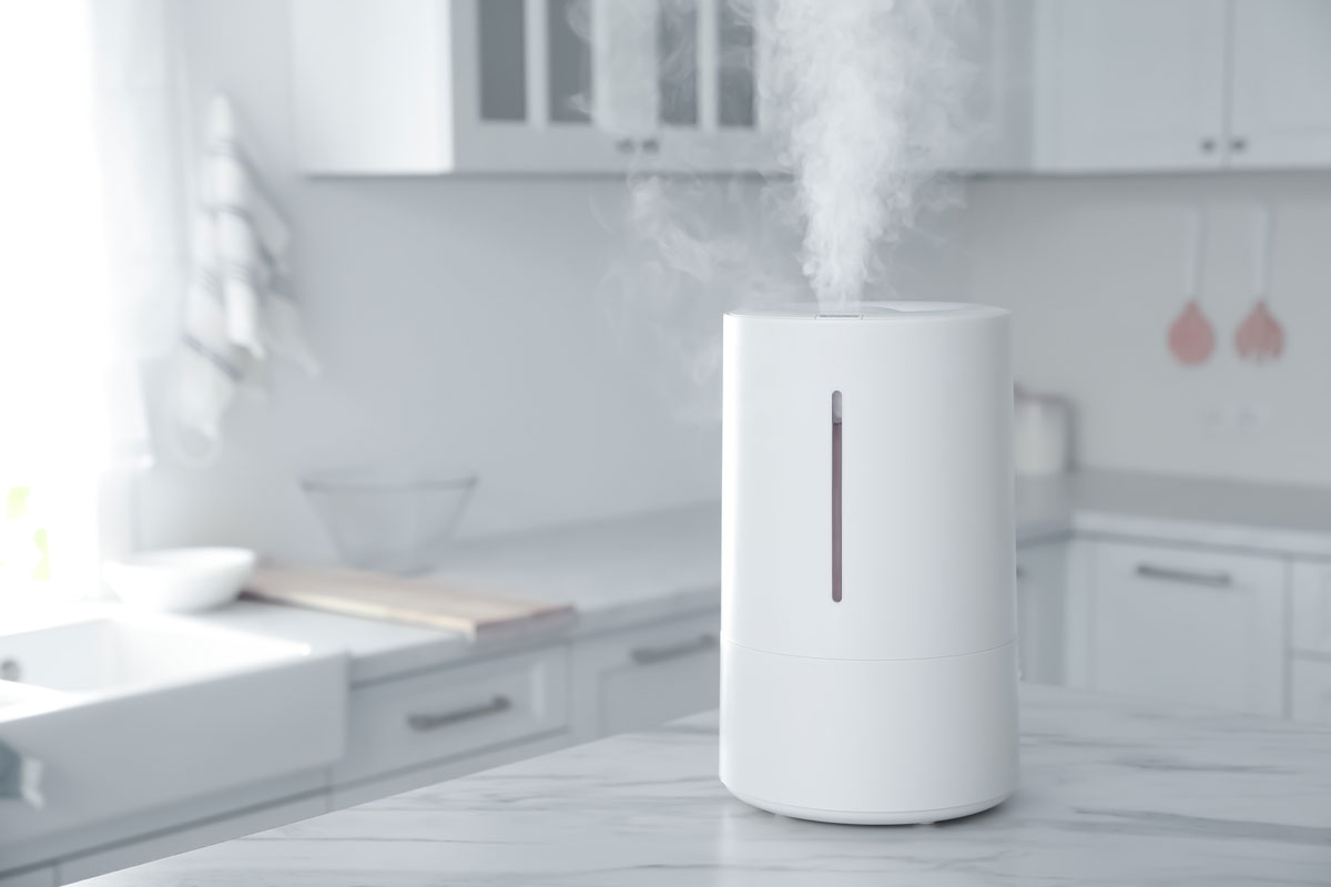 Modern air humidifier on table in kitchen
