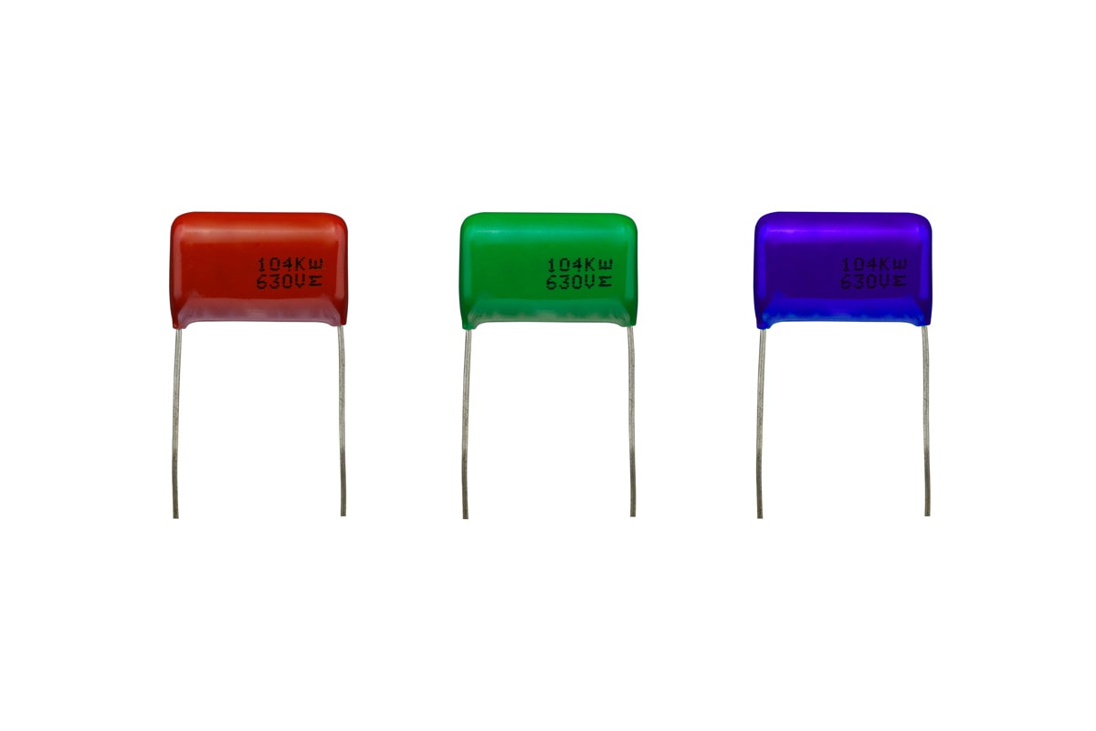 Mylar polyester capacitors with a brown and a green and a blue color isolated on white background. electronics part concept.