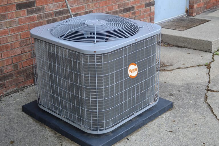 Payne heat pump near the wall of a building, Why Does My Payne Heat Pump Keep Freezing Up?