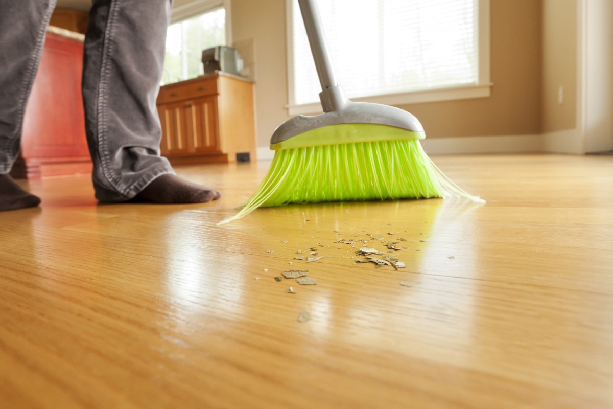 Person sweeping mess on hardwood floor