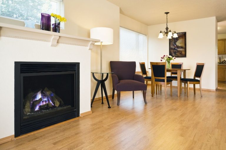 Spacious living area with hardwood floors. A fireplace and dining table are in view. Horizontal shot. - How To Light A Gas Fireplace With Electronic Ignition?