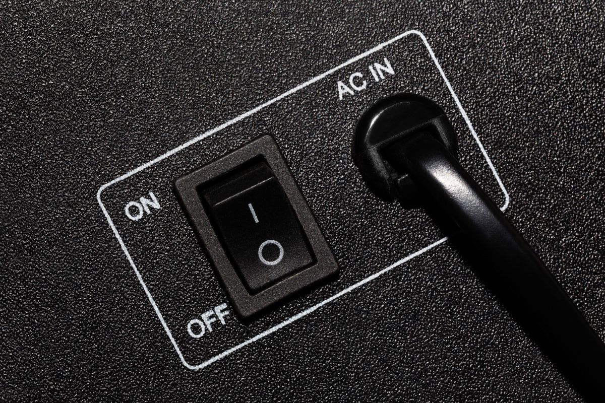 The panel of the household appliance with the power cord and switch, closeup.