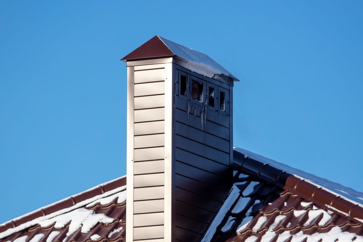 Ventilation pipe on the roof of a house with snow winter season
