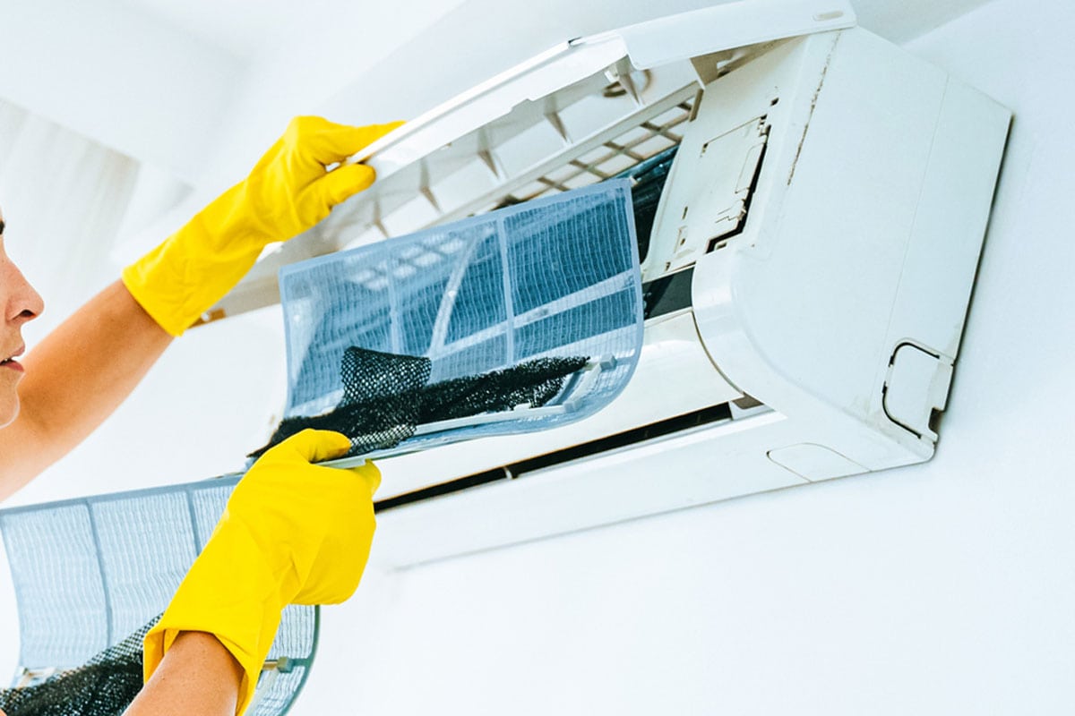 Woman Cleaning Air Conditioning System