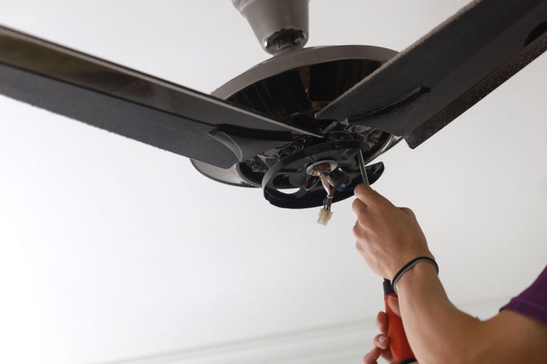 close-male-electrician-fixing-installing-ceiling-white ceiling, My Minka Aire Fan Makes A Clicking Noise - Why? How To Fix It?