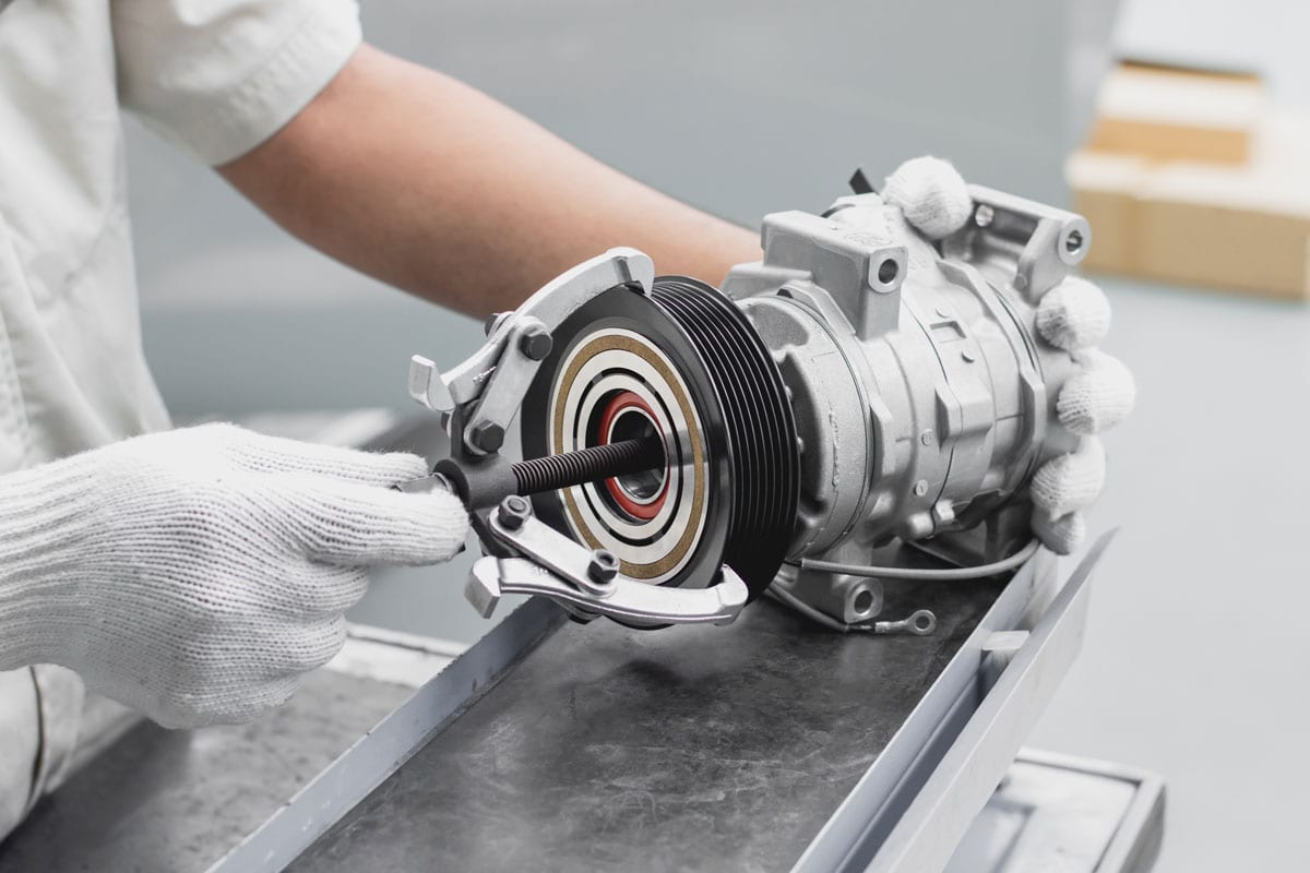 close-mechanics-hand-that-giving-special, Can You Replace Just The Clutch On An AC Compressor? Should You?