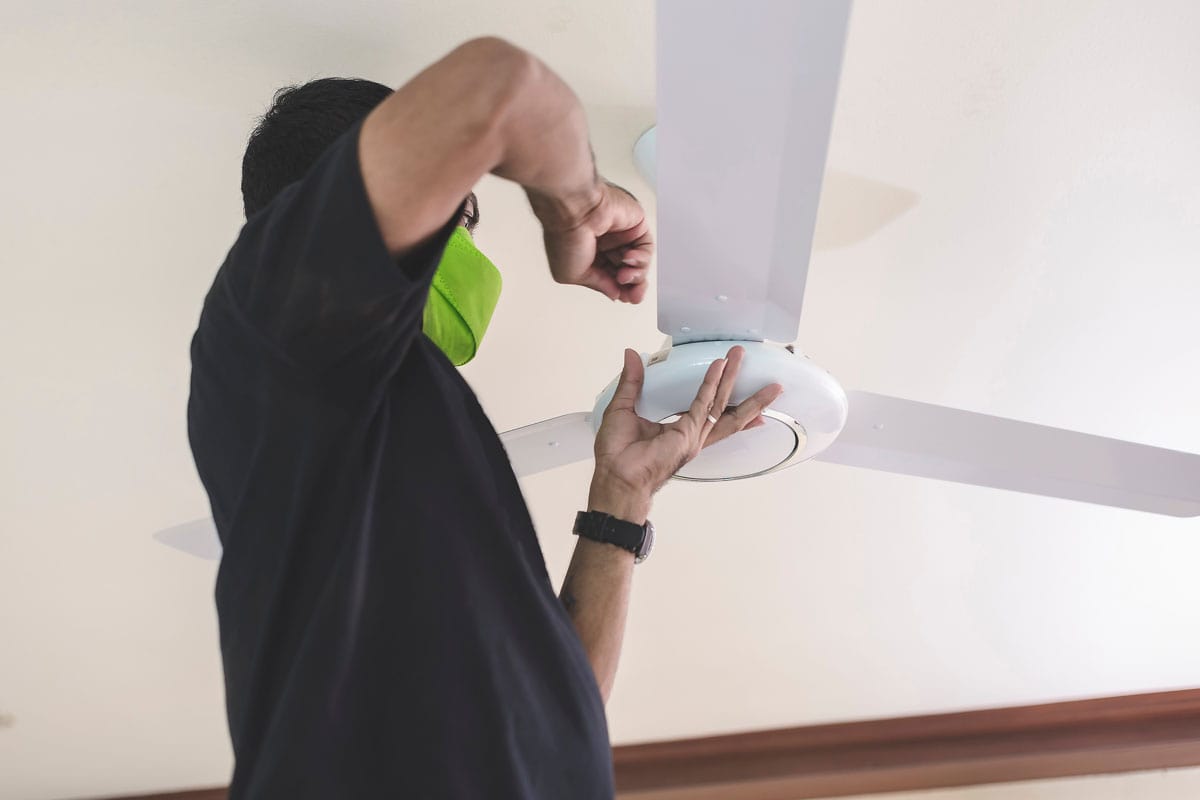 handyman-installs-ceiling-fan-tightening-screws