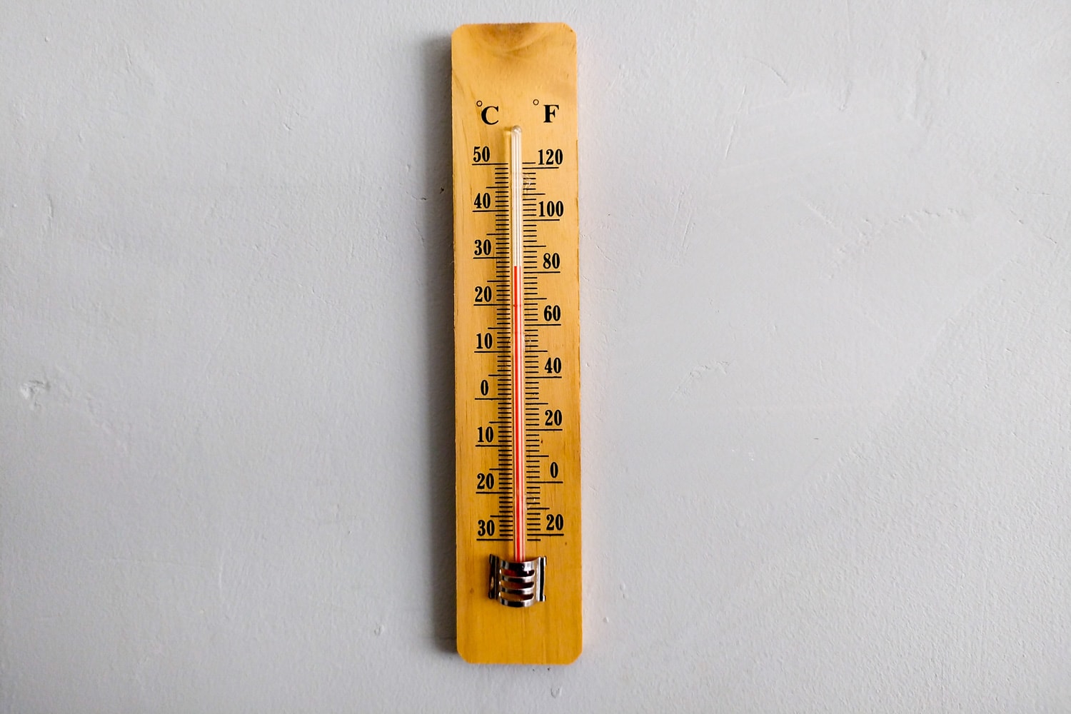 A wooden thermometer with mercury, mounted on the wall to measure room temperature, a temperature thermometer with two readings of Celsius and Fahrenheit