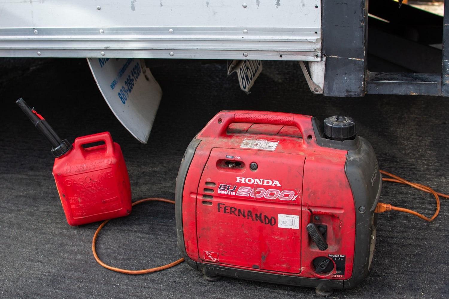 A Honda EU 2000i Inverter generator and gas can sit by a truck at the Canoga Park Farmer's Market on Owensmouth Ave.