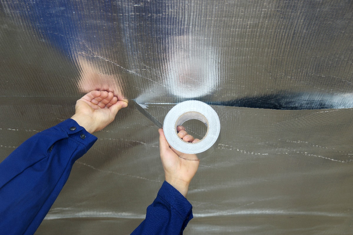 Builder attaches vapor barrier membrane to protect the mineral insulation