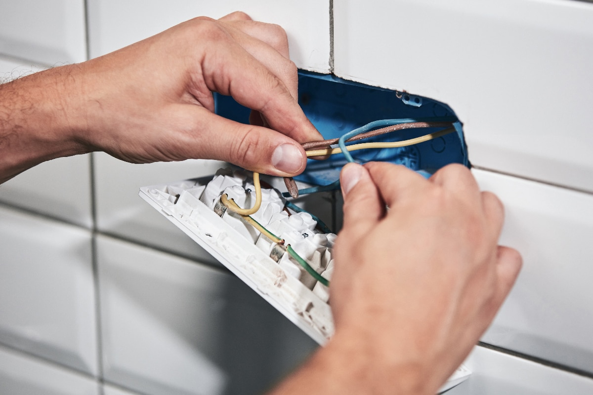 Electrician repairing and fixing wires in the electrical socket