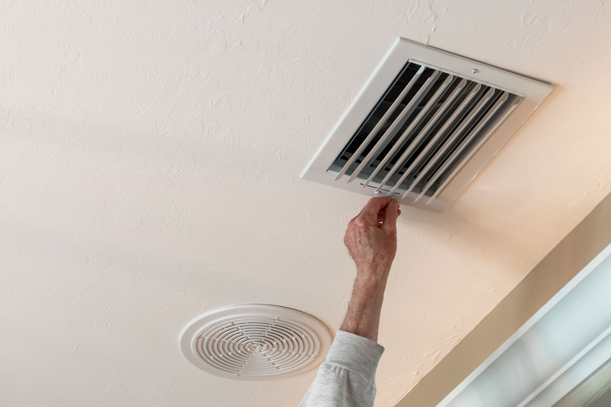 Handyman adjusting HVAC ceiling air vent