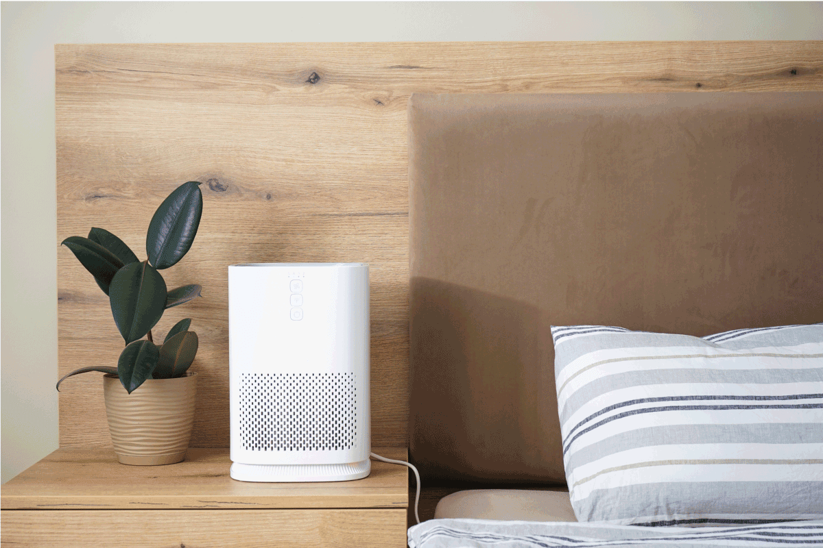 Modern air purifier in the bedroom by the bed, place for text. 