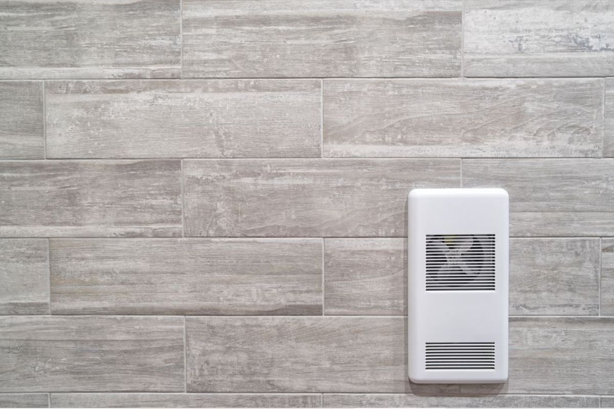 Recessed wall mounted heater against a grey ceramic wall