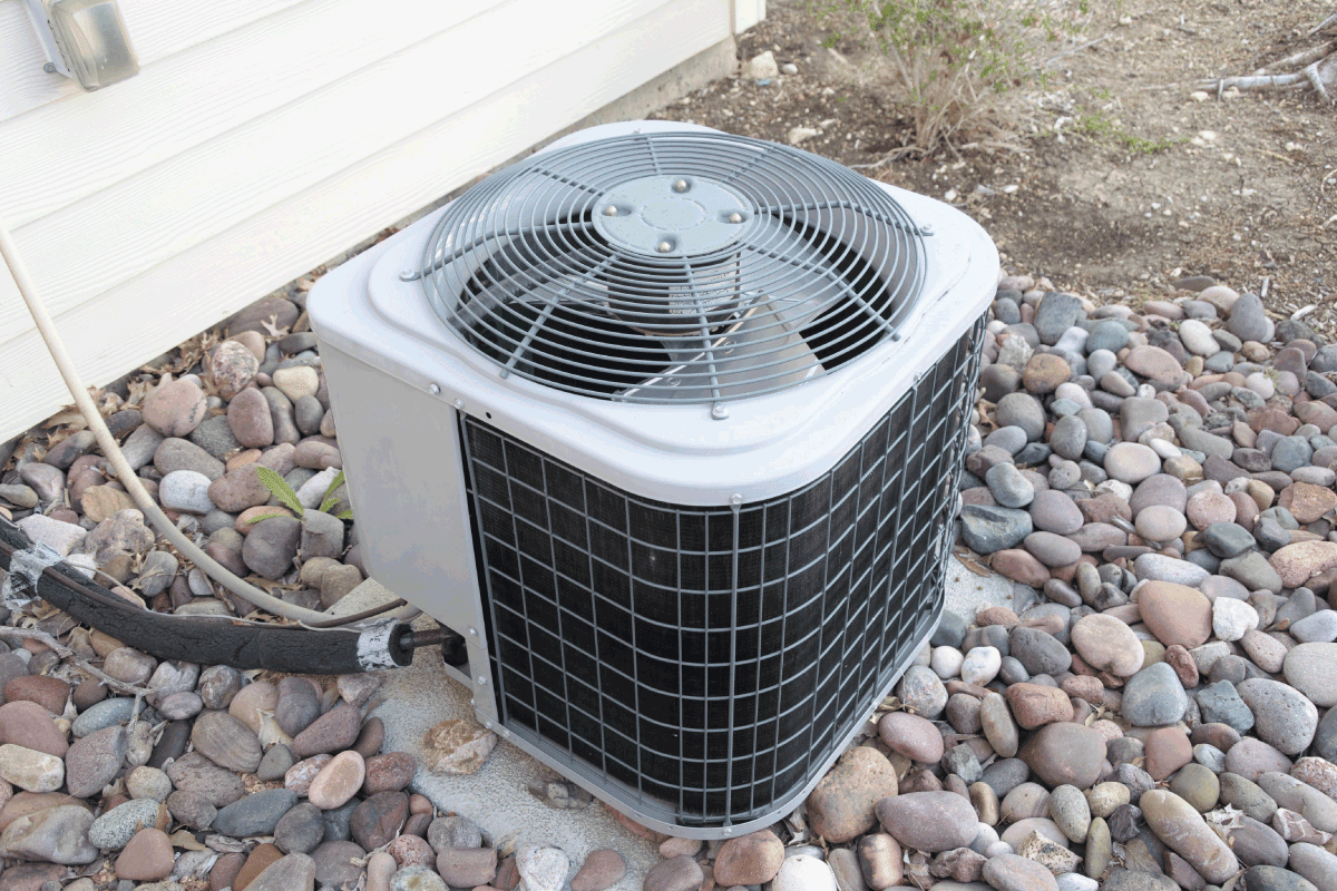 Residential Air Conditioner Unit outside the house with rock landscaping 