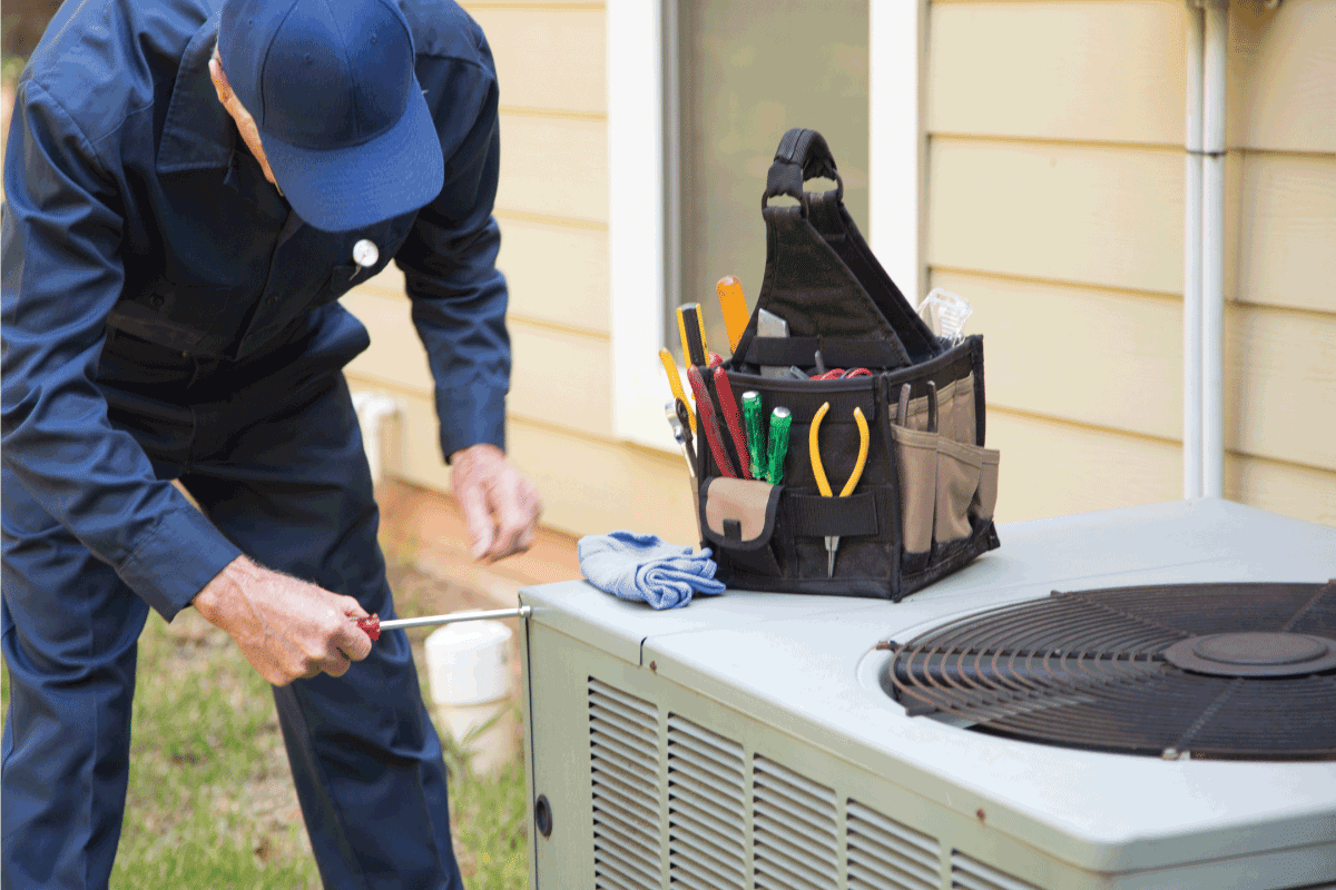 air conditioner Technician installs outdoor AC unit
