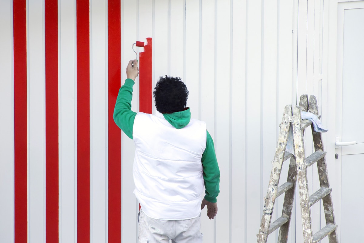 painter man working for repairing and painting the garage door 