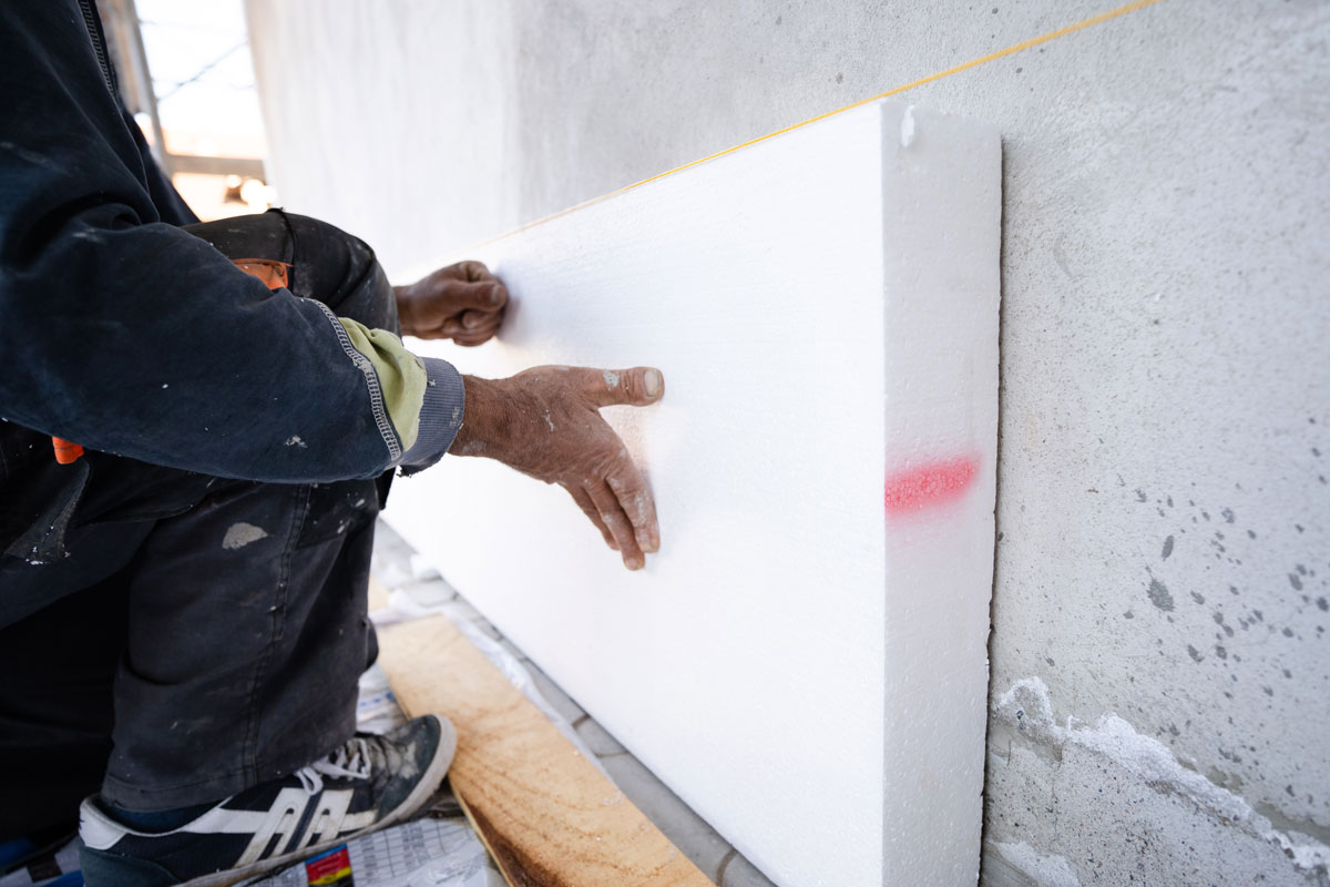 worker-placing-styrofoam-sheet-insulation-wall
