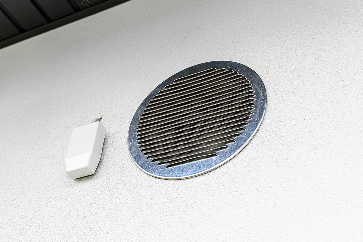 Air intake and exhaust in the wall of a single family house for mechanical ventilation with heat recovery, secured with a metal grill with mesh