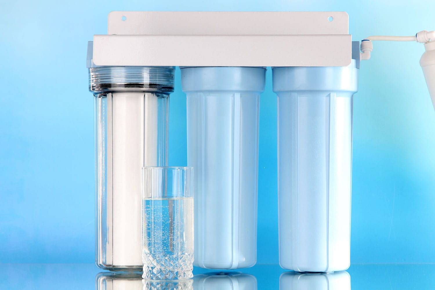 Filter system for water treatment with glass on blue background 