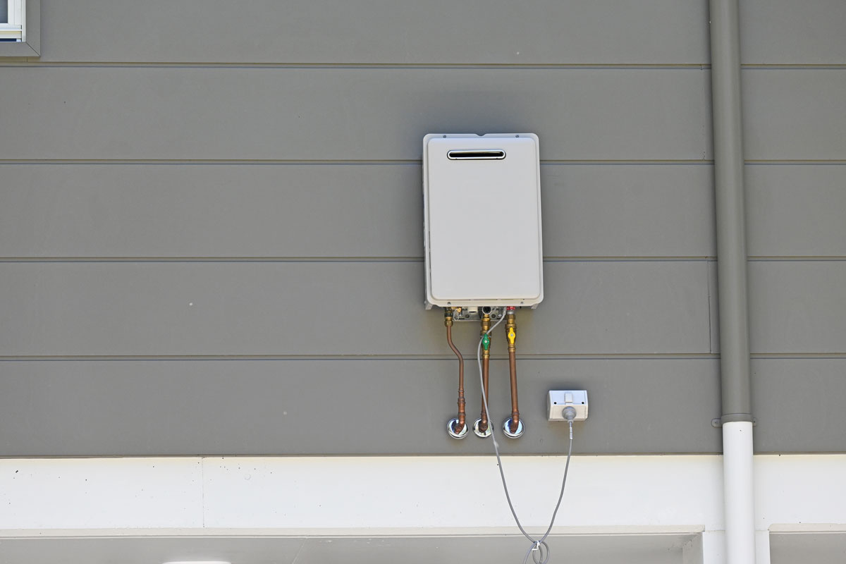 Instantaneous gas hot water heater on the side of a house