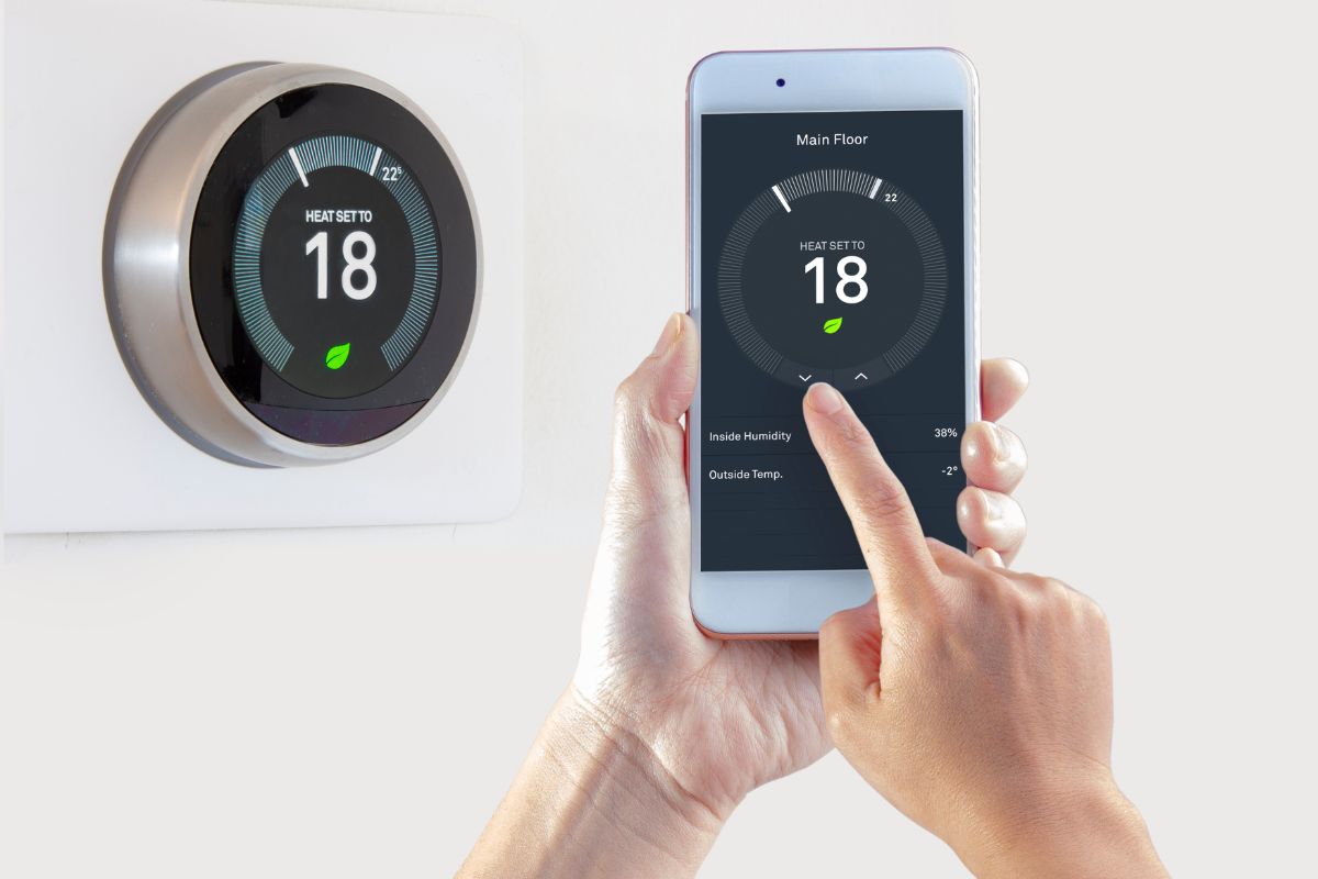 Smart Thermostat with a person saving energy with a smart device on a white background.