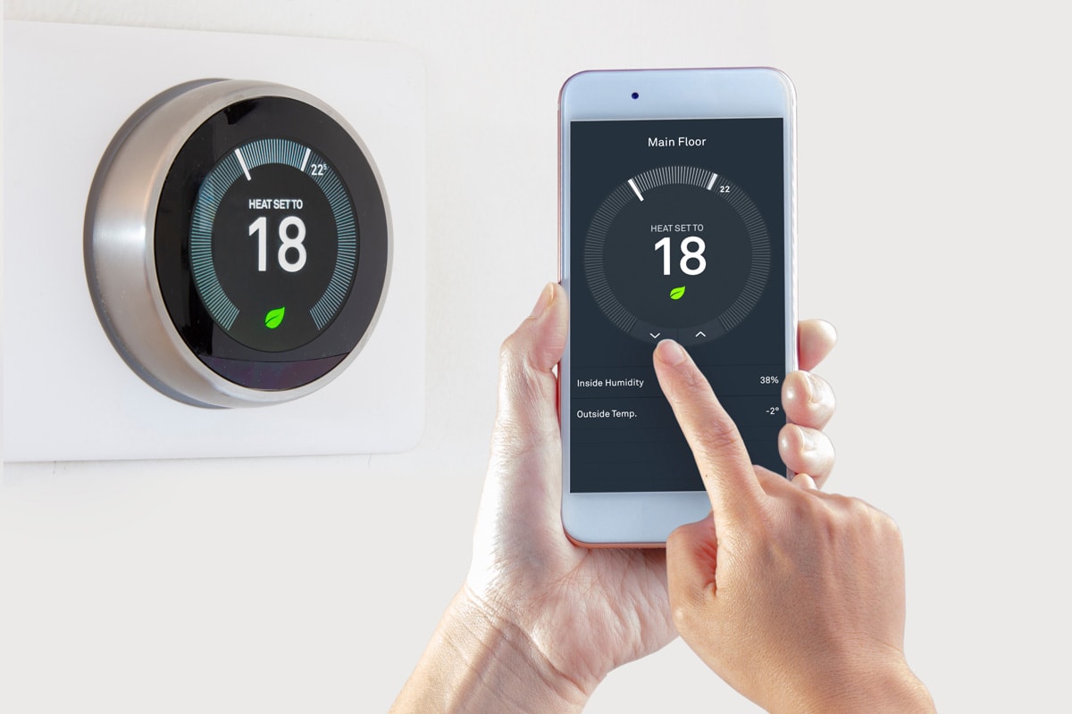 Smart Thermostat with a person saving energy with a smart device on a white background