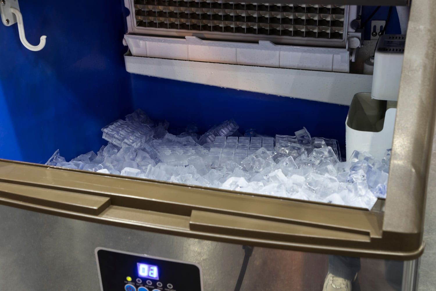 cube ice from clean water in ice making machine for restaurant food industry background close up