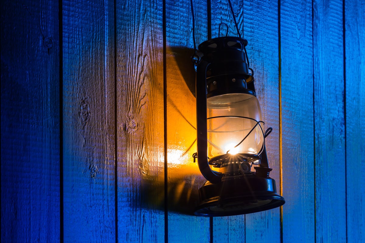 old kerosene lantern hanging on wooden
