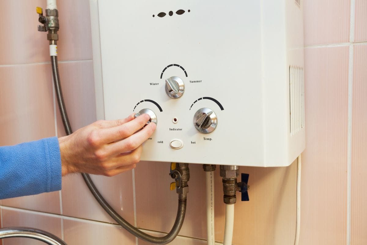 Men hand regulate the power of hot water in Gas water heater.
